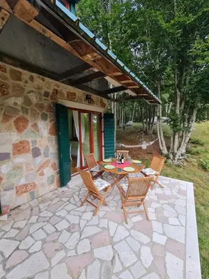 a patio with a table and chairs in front of a house at Lovćen Escape, Rustric House in Cetinje