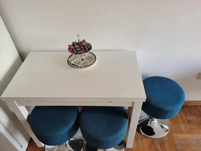 a white table with blue chairs and a plate on it at Dina's Place in Podgorica