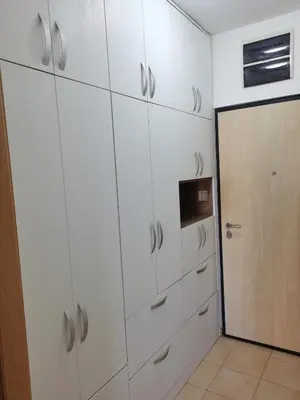a white kitchen with white cabinets and a door at Dina's Place in Podgorica