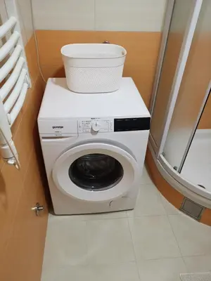 a washing machine with a bowl on top of it at Dina's Place in Podgorica