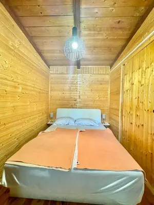a bedroom with a bed in a wooden room at Jungle 1 House Ada Bojana in Ulcinj
