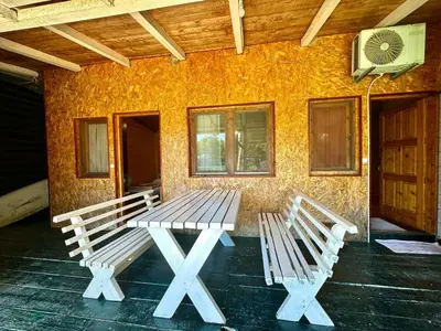 two white benches sitting in front of a building at Jungle 1 House Ada Bojana in Ulcinj