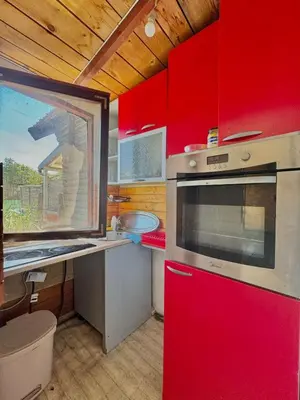a kitchen with red cabinets and a red oven at Jungle 1 House Ada Bojana in Ulcinj