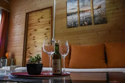 a table with two wine glasses and a couch at Jungle 1 House Ada Bojana in Ulcinj