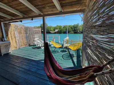 a hammock on a deck with a view of the water at Jungle 1 House Ada Bojana in Ulcinj