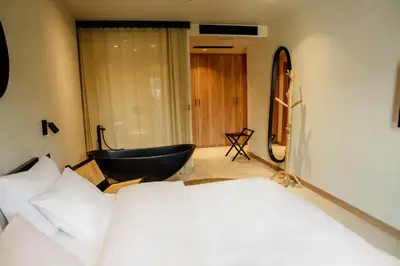 a bedroom with a bed and a black chair at Hotel 1920 in Podgorica