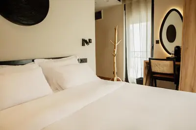 a bedroom with a white bed and a mirror at Hotel 1920 in Podgorica