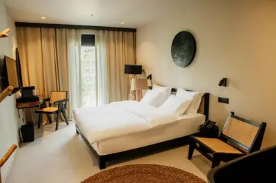 a bedroom with a large white bed and a chair at Hotel 1920 in Podgorica