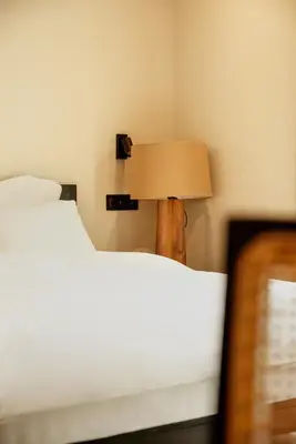 a lamp sitting next to two beds in a room at Hotel 1920 in Podgorica