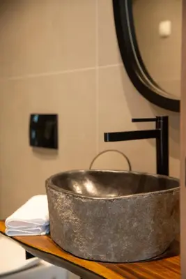 a metal sink sitting on a counter in a bathroom at Hotel 1920 in Podgorica