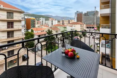 a table with a bowl of fruit on a balcony at Apartments Centar Montesun in Budva
