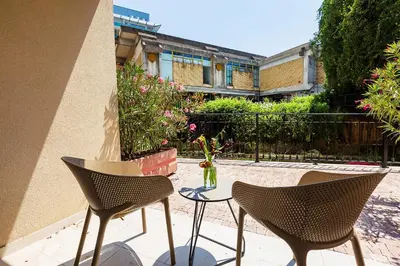 two chairs and a table with a vase of flowers on a patio at Apartments Centar Montesun in Budva