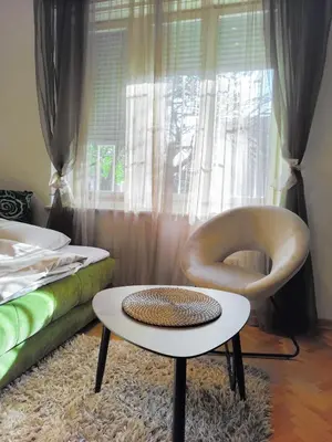 a living room with a chair and a table at Studio apartment CENTER in Podgorica