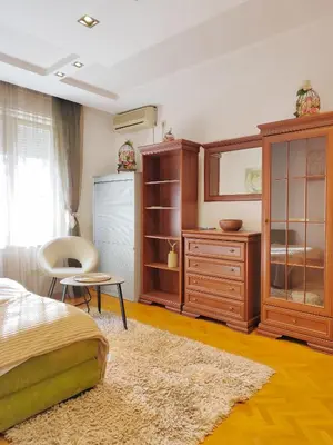 a bedroom with a bed and a dresser at Studio apartment CENTER in Podgorica