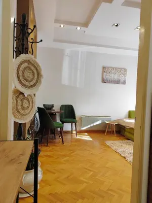a living room with a table and green chairs at Studio apartment CENTER in Podgorica