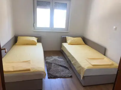 two beds in a small room with a window at Lina Apartment in Bar