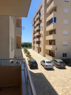 two cars parked in a parking lot next to a building at Lina Apartment in Bar