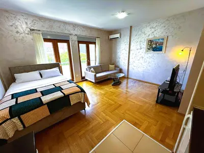 a bedroom with a bed and a living room at Renta Stanovi Podgorica in Podgorica