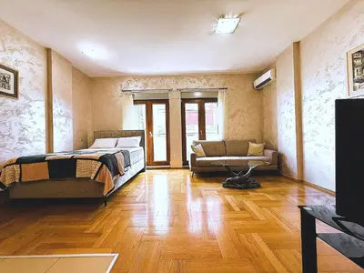 a bedroom with a bed and a couch in a room at Renta Stanovi Podgorica in Podgorica