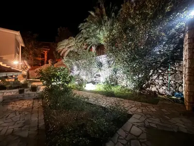 a building with lights on the side of it at night at Stone Villa Guesthouse in Budva