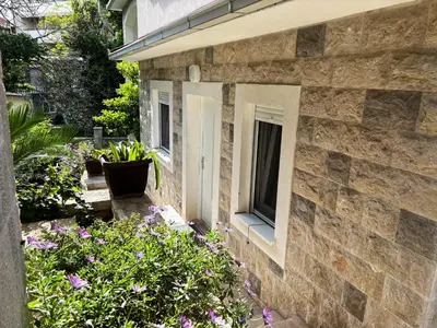 a stone house with a window and flowers at Stone Villa Guesthouse in Budva