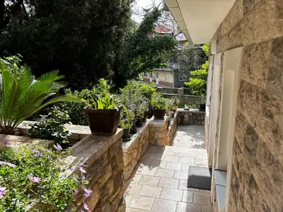 a garden with potted plants on a stone wall at Stone Villa Guesthouse in Budva