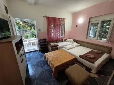 a small room with two beds and a table at Stone Villa Guesthouse in Budva