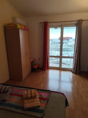 a bedroom with a bed and a large sliding glass door at Apartments Kalamperovic in Bar