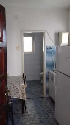a kitchen with a table and a refrigerator at Apartments Kalamperovic in Bar