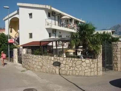 a building with a stone wall next to a building at Apartments Kalamperovic in Bar
