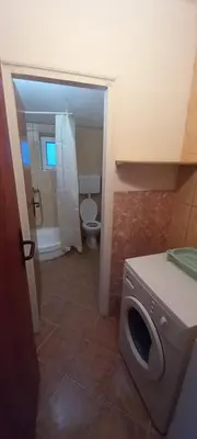 a bathroom with a toilet and a washing machine at Apartments Kalamperovic in Bar