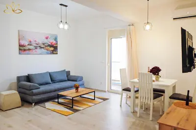 a living room with a blue couch and a table at Apartment Lotus in Ulcinj