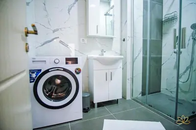 a bathroom with a washing machine and a sink at Apartment Lotus in Ulcinj