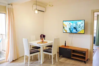 a dining room with a white table and chairs at Apartment Lotus in Ulcinj