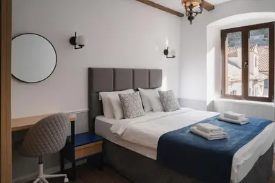 a bedroom with a bed with a chair and a mirror at Nest 382 in Kotor