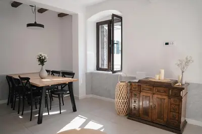 a dining room with a table and chairs and a window at Nest 382 in Kotor