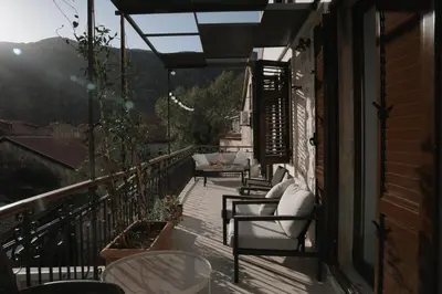 a balcony with chairs and tables on a house at Nest 382 in Kotor