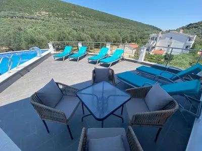 a patio with chairs and tables and a swimming pool at PRINCESS - Valdanos in Ulcinj