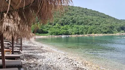a beach with chairs and umbrellas next to the water at PRINCESS - Valdanos in Ulcinj