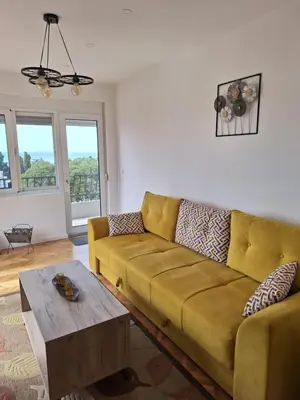 a living room with a yellow couch and a table at Rudovic Apartments in Ulcinj
