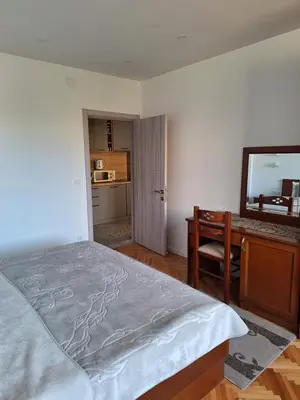 a bedroom with a bed and a desk and a mirror at Rudovic Apartments in Ulcinj