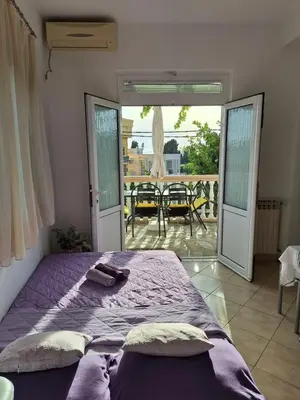 a bedroom with a purple bed and a patio at Rudovic Apartments in Ulcinj