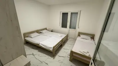 a bedroom with two beds and a window and a mirror at Sabo Villa in Pečurice