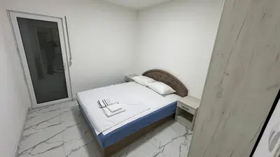 a small white bedroom with a bed and a mirror at Sabo Villa in Pečurice