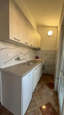 a kitchen with white cabinets and a sink at Sabo Villa in Pečurice