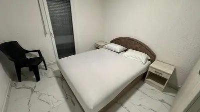 a small bedroom with a bed and a chair at Sabo Villa in Pečurice