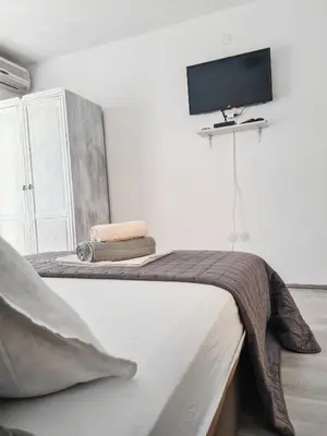 a bedroom with a bed with a tv on the wall at Lemon&Olives in Budva