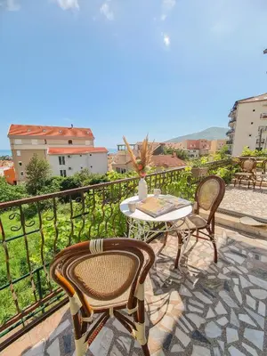 a patio with a table and chairs on a balcony at Lemon&Olives in Budva