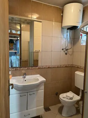 a bathroom with a sink and a toilet and a mirror at City Heart Apartments 2 in Ulcinj