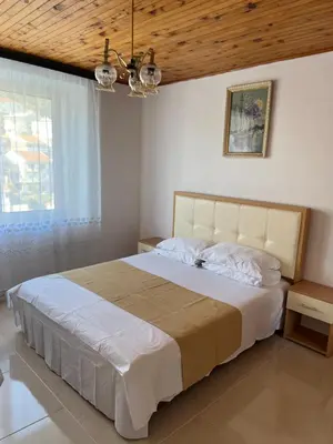 a bedroom with a large bed with a wooden ceiling at City Heart Apartments 2 in Ulcinj